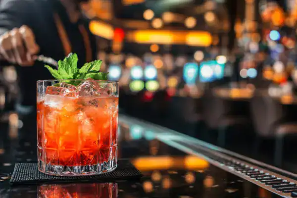 A bartender garnishes a cold drink