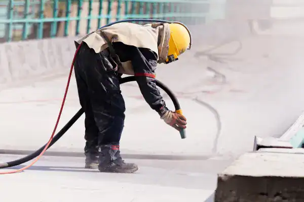 A worker blasts with dry ice
