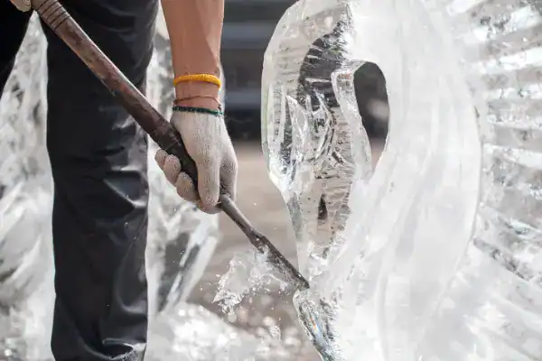 An artist carves an ice sculpture